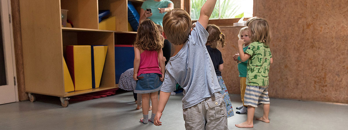 a child stretches as if a tree envisaging the rain
